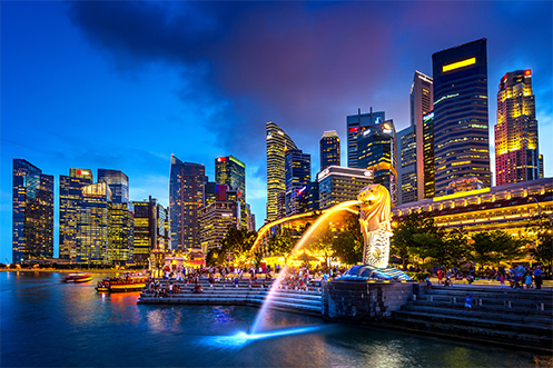 Singapore skyline at night, lion fountain streaming water into bay, named most livable city