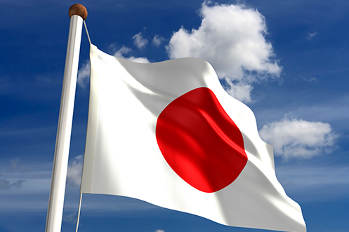 Japan flag on flagpole against blue sky Japan to Create New Work Permit Labor Reform Law