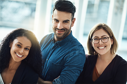 Woman with curly brown hair smiling, man standing with brown hair and beard and blue shirt smiling, and woman with blonde hair and glasses smiling, all are the new Mobility Manager for their companies