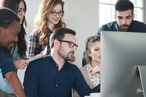 Group of six information technology coworkers, three men, three women, all looking at a computer screen, programming a new relocation API
