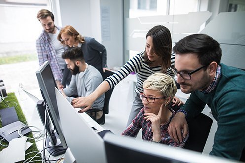 Group of six Toronto tech talent workers, three men, three women, all facing computer screens, looking at projects