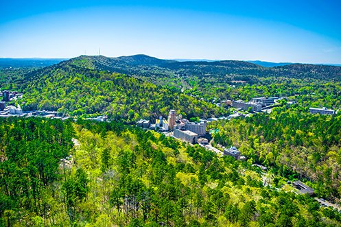 Beautiful Arkansas wilderness showing mountains and small city where those who utilize the Northwest Arkansas moving incentive can enjoy their new lifestyle