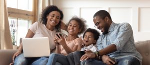 family laughing while looking at laptop
