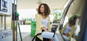 young woman filling up her car at the gas pump