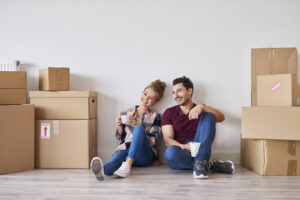 Young couple moving into a new home with all their household goods in boxes