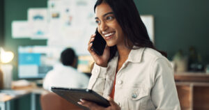 young woman on the phone while using tablet