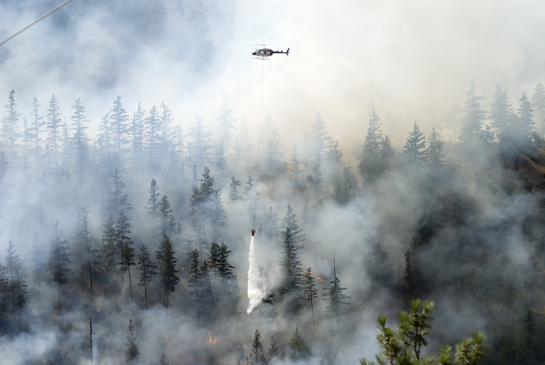 helicopter flying over wildfire