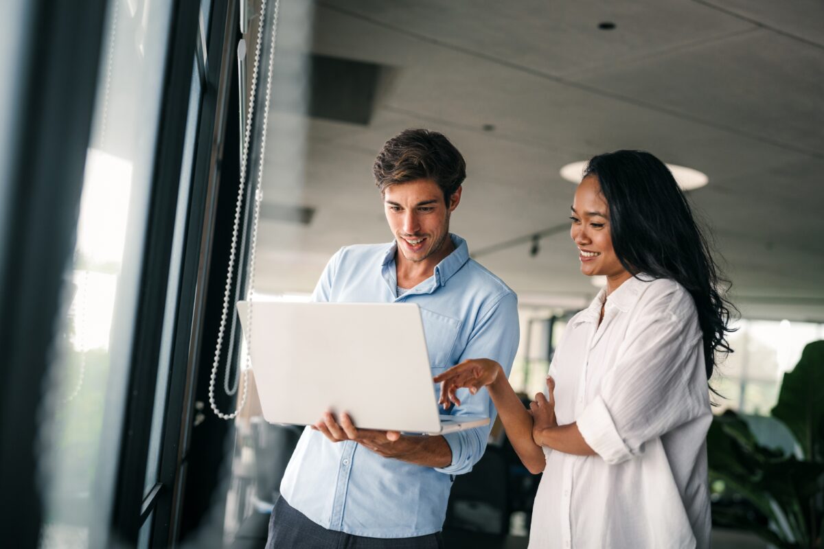 Two coworkers reviewing relocation costs on a laptop