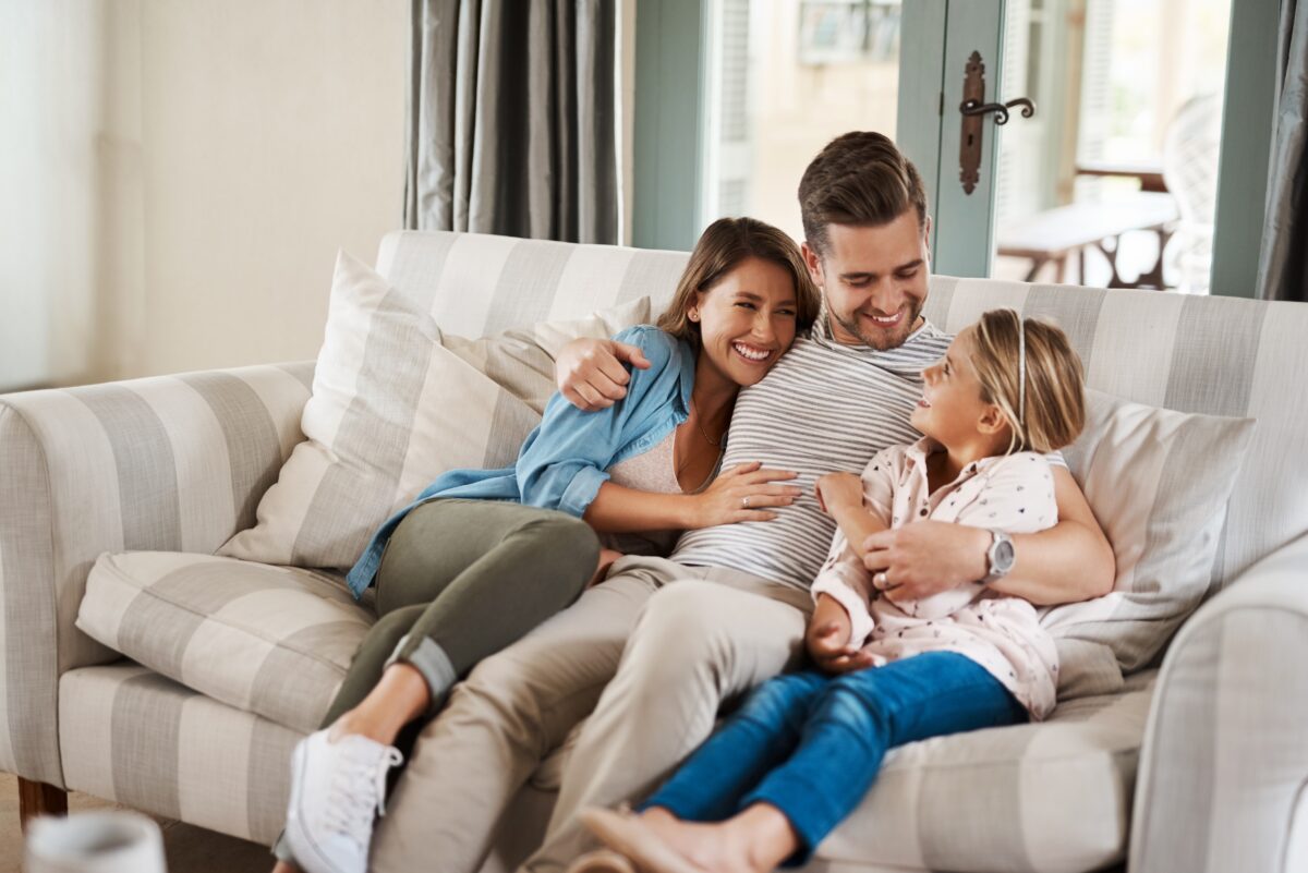 Young family laughing on the couch