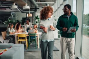 two African-American coworkers discussing the company's visa and immigration policies.