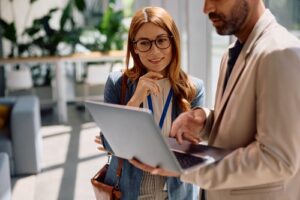 Coworkers reviewing relocation software on a laptop