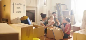 family enjoying pizza in their new home with moving boxes around
