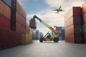 airplane flying over large shipping containers