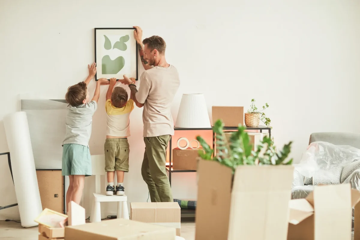 family hanging photos in the home they just relocated to