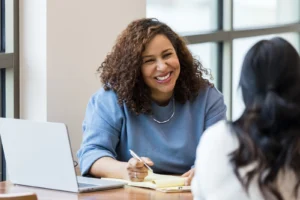 two women discuss relocation packages in a job interview