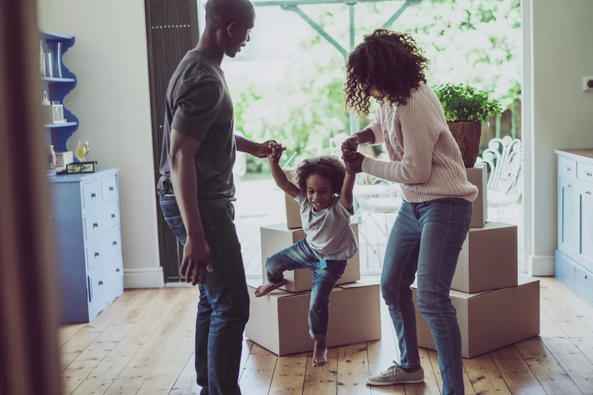 young family playing while they move in to their new home