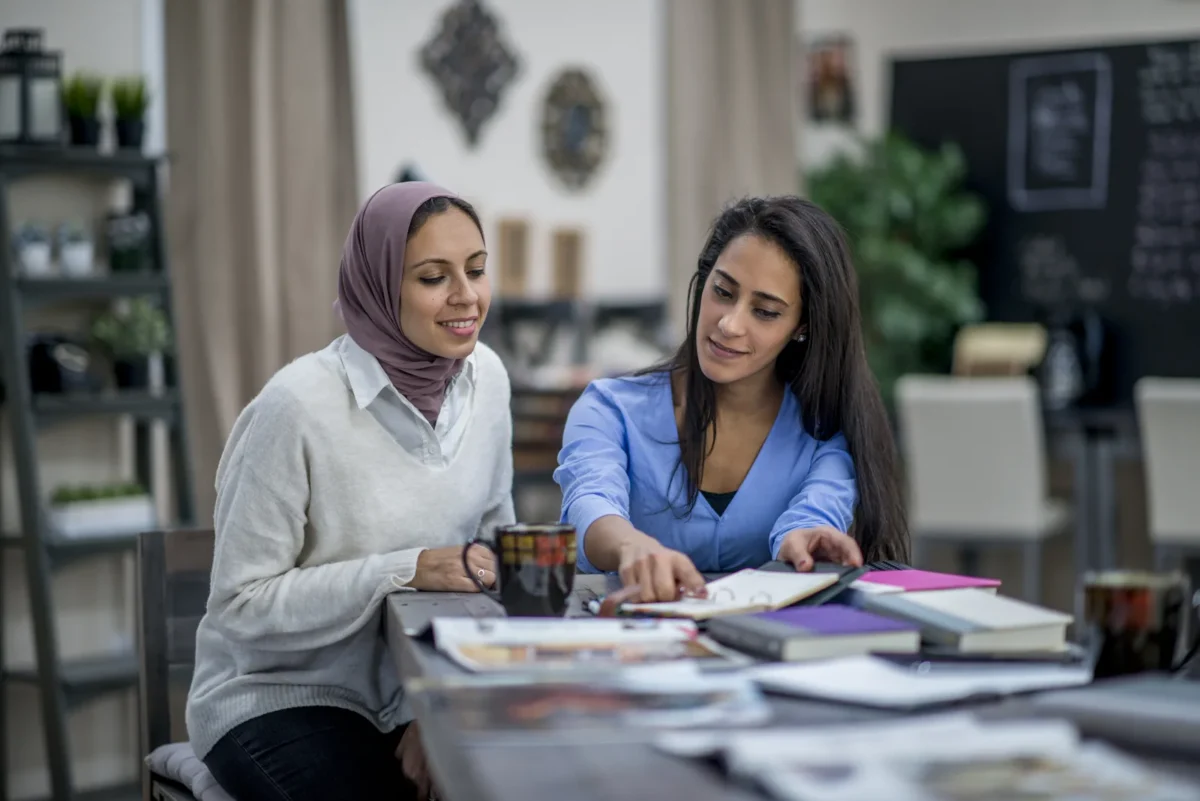two women review visa and immigration paperwork