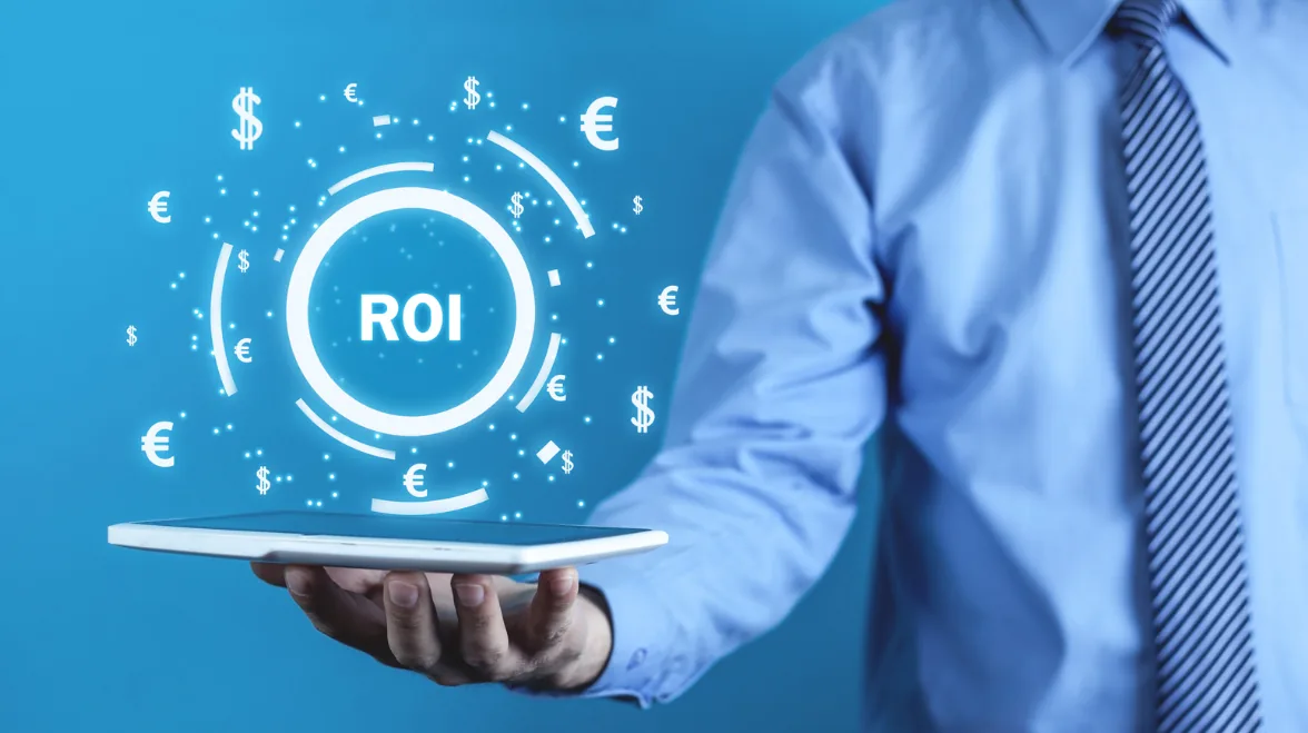 man holding computer with ROI letters and currency signs