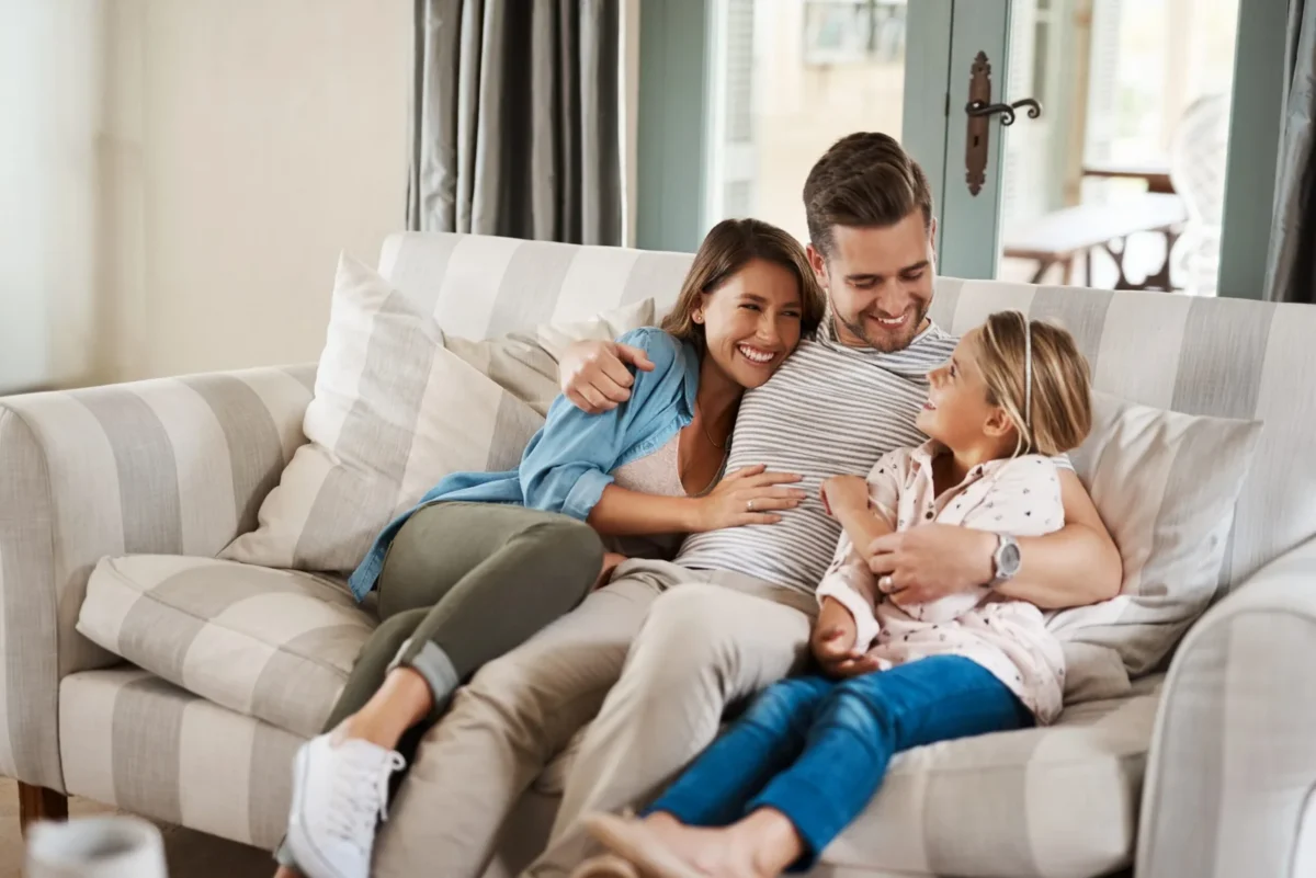 Young family laughing on the couch